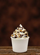Soft vanilla ice cream with Chocolate sauce and hazelnut / filbert sundae or frozen custard isolated on brown background