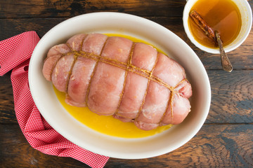 Wall Mural - Raw stuffed turkey breast fillet and sauce for baking with honey, orange juice and cinnamon. Wooden rustic table, top view