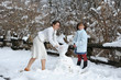 © Sergio Yoneda - Young mother with her daughter playing with snow next to a fence of tree trunk. Shizuoka Prefecture, Japan. Winter of February 2011.