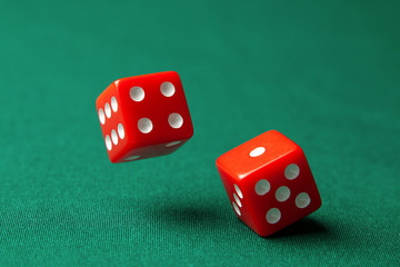 Two red dice on green poker gaming table in casino. Concept online gambling