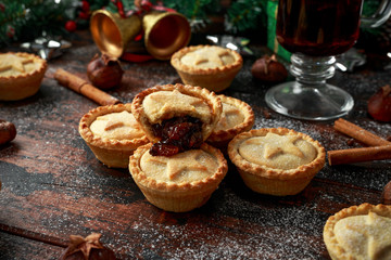 British Christmas mince pies with decoration, gifts, green tree branch on wooden rustic table