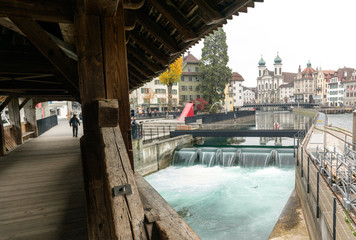 Sticker - Lucerne, LU / Switzerland - November 9, 2018: the famous Swiss city of Lucerne cityscape skyline and Jesuit church with the river Reuss panorama view and the historic Rathaussteg with tourists in the 