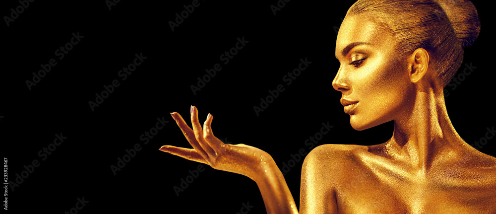 Golden woman. Beauty fashion model girl with golden skin, makeup, hair and jewellery on black background. Fashion art portrait - obrazy, fototapety, plakaty 