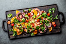 Whole Octopus Salad With Orange, Tomatoes And Cress Salad Served On Board With Wine