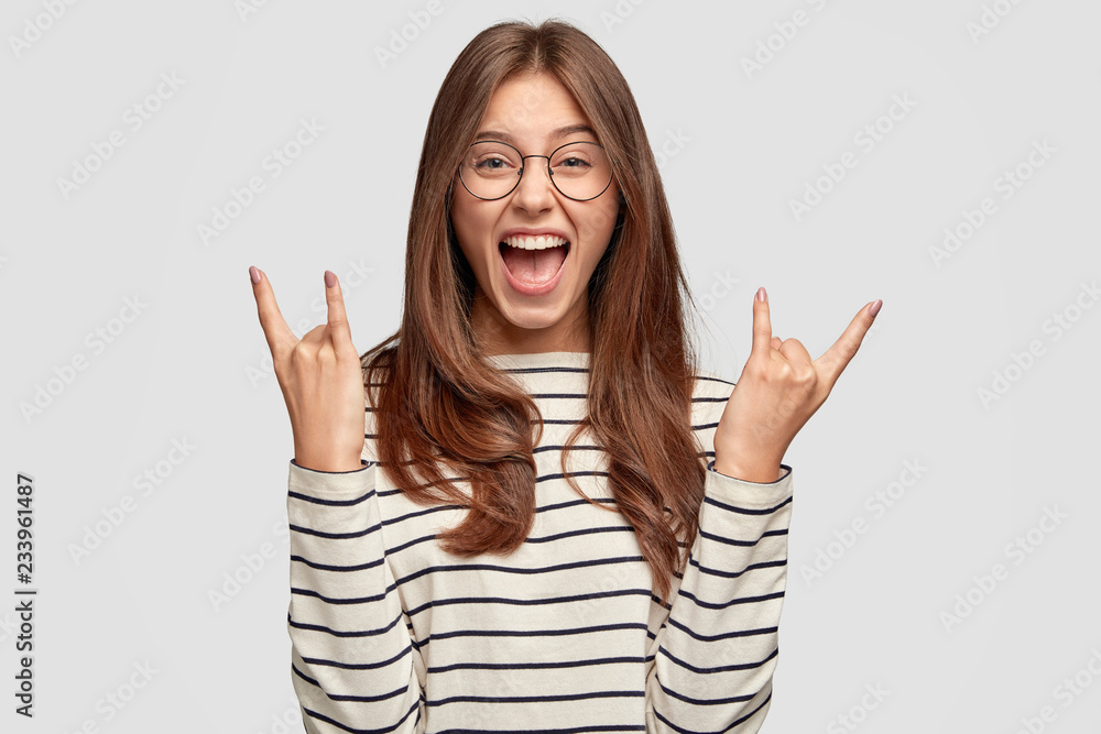 Smiley Rocker Girl Crazy overjoyed woman makes rock n roll gesture, wears transparent ...