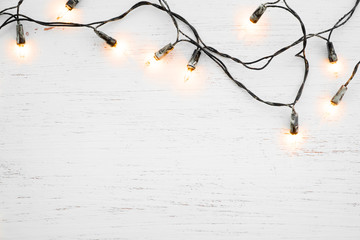 Wall Mural - christmas lights bulb decoration on white wood. merry christmas and new year holiday background. top