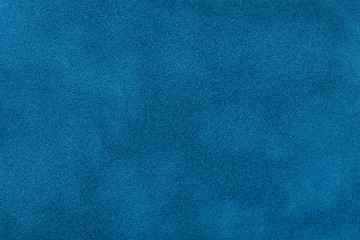 Dark blue matte background of suede fabric, closeup.