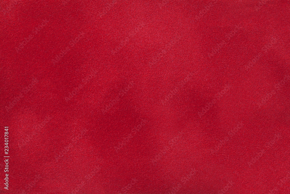 Dark red matte background of suede fabric, closeup.