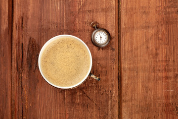 Poster - A cup of coffee and a vintage watch showing 7 o'clock, shot from the top on a dark rustic wooden background with a place for text