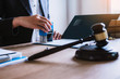 © ordinary042 - Business woman sitting with brass scale at lawyer desk, Lawyer working hand holding automatic stamp important documents in office. lawyer and law ,judiciary and legislature courtroom legal concept.