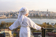 © Корнеевец-Выдренкова - Woman in bathrobe on the terrace of a house at sunrise
