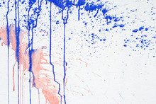 White Plastered Wall With Drips Or Flows And Paint Sprays. Pink And Blue Paint Dripping Down On White Surface.