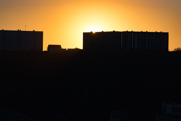 Poster - urban landscape with silhouettes of high-rise buildings in the background light of the sunset.