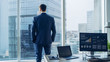 © Gorodenkoff - Confident Businessman in a Suit Contemplating Business Deal in His Office, Looking out of the Window. Window Has Panoramic View on Big City Business District.
