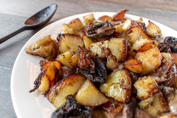 Side dish of roasted vegetables of carrots, potatoes, onions, and mushrooms