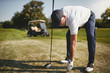 Senior man preparing to tee off on a golf course
