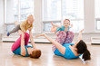 © anoushkatoronto - Group of two young women with children doing workout in gym class to loose baby weight. Child-friendly fitness for mothers with kids. Lifestyle concept of family activity for moms.