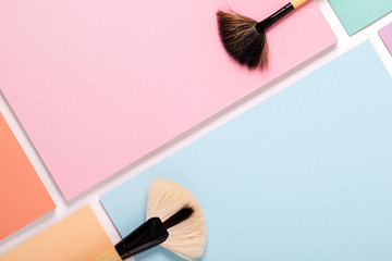 makeup brushes on pastel paper pink background