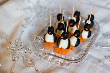 Healthy fun art food snacks as appetizers or for children in the shape of penguins with carrots, mozzarella cheese and olives