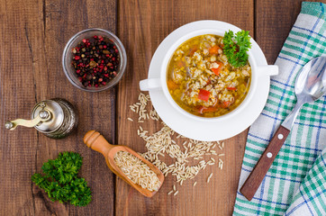 White bowl of chicken and wild rice soup with vegetables