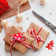  DIY presents wrapped in craft paper. Gifts tied with white and red threads with red heart symbol.