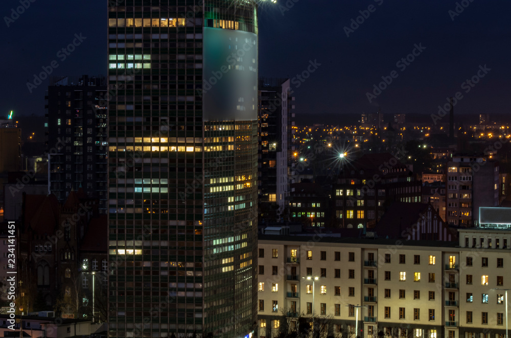 Widok na budynki miejskie nocą.  - obrazy, fototapety, plakaty 