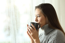 Happy Woman Drinking Coffee Looking Rain Through A Window