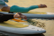 Closeup photo of two women doing yoga exercise on sup board
