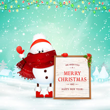 Merry Christmas. Happy New Year. Funny Snowman Holds Wooden Message Board In Christmas Snow Scene Winter Landscape With Falling Snow, Garlands. Happy Snowman Cartoon Character.