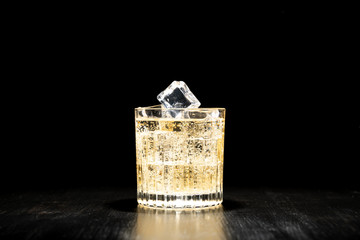 Wall Mural - dark background whiskey ice glass ice hand photo moody pouring alcohol bourbon bartender bar hotel home