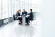 © opolja - Businesspeople discussing together in conference room during meeting at office.