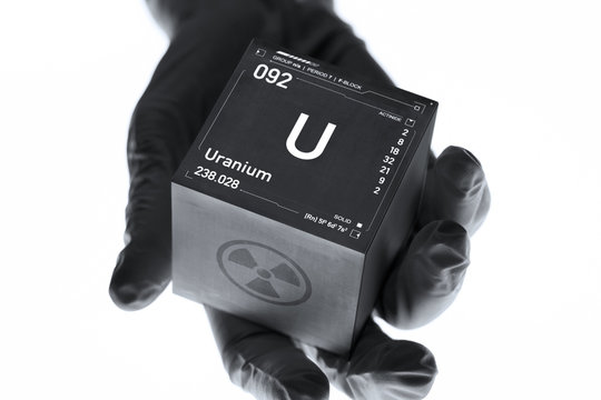 Uranium cube in the hand of a scientist. Radioactive element from the periodic table.