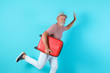 Senior man with suitcase running on color background. Vacation travel