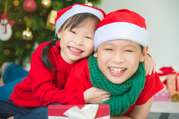 Wall Mural - Young asian sibling,brother and sister smiling together at home with Christmas decoration