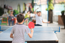 Kid Playing Table Tennis Outdoor With Family