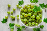 Green fresh gooseberry fruits in a bowl, top view