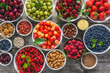 Fototapeta Kuchnia - Organic food selection. Fruit, fresh berries and nuts. Healthy superfood assortment.