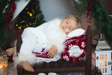 Canvas Print - Adorable little toddler baby boy dressed in canta claus costume, sleeping in baby bed in front of Christmas teepee