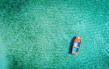 Aerial Photo Of A Red Lonely Tboat Tied Up In Crystal Clear Turquoise Sea Water