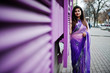 © AS Photo Family - Indian hindu girl at traditional violet saree posed at street against purple windows.