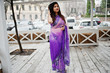 © AS Photo Family - Indian hindu girl at traditional violet saree posed at street against wooden terrace.