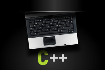 C++ programming language. Laptop on c++ on black background