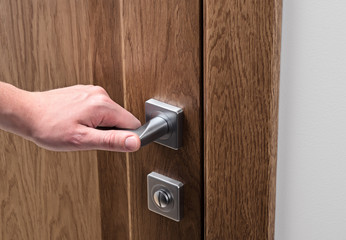 The man opens the door. Close - up of hand and door handle..