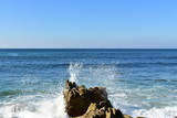 Fototapeta Morze - Waves splashing against the rocks. Blue sea and white foam. Sunny day, blue sky, Galicia, Spain.