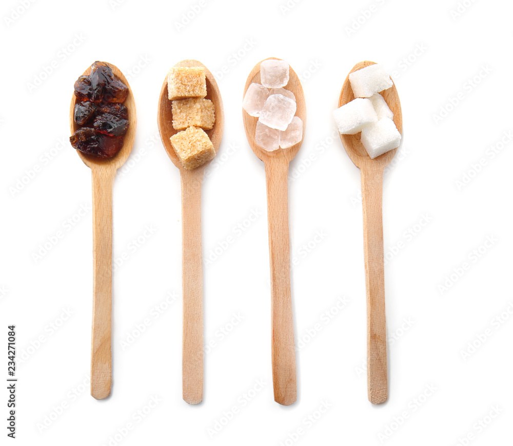 Wooden spoons with different kinds of sugar on white background