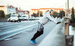 © Halfpoint - Mature male runner with headphones stretching outdoors on the bridge in Prague city.