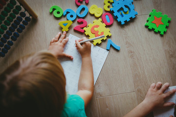 Wall Mural - little boy and girl learn to write and calculate numbers