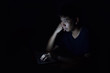 © DrKlum - Asian man using laptop in the black dark room and show thinking something on his face
