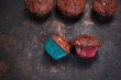 Babeczki czekoladowe w kolorowych papilotkach. Domowe czekoladowe ciasteczka na ciemnym stole.