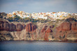 View of Oia village with white houses on red rocks caldera of Santorini Island, Greece